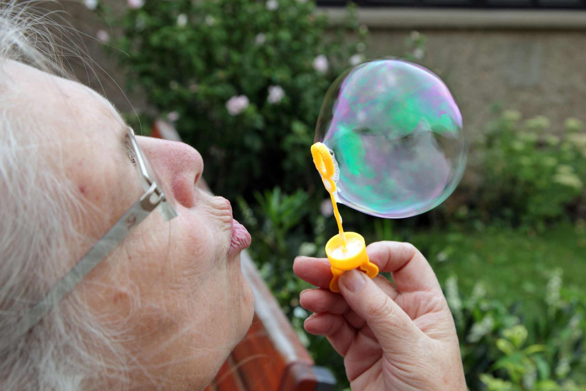 Seniorin mit Seifenblase