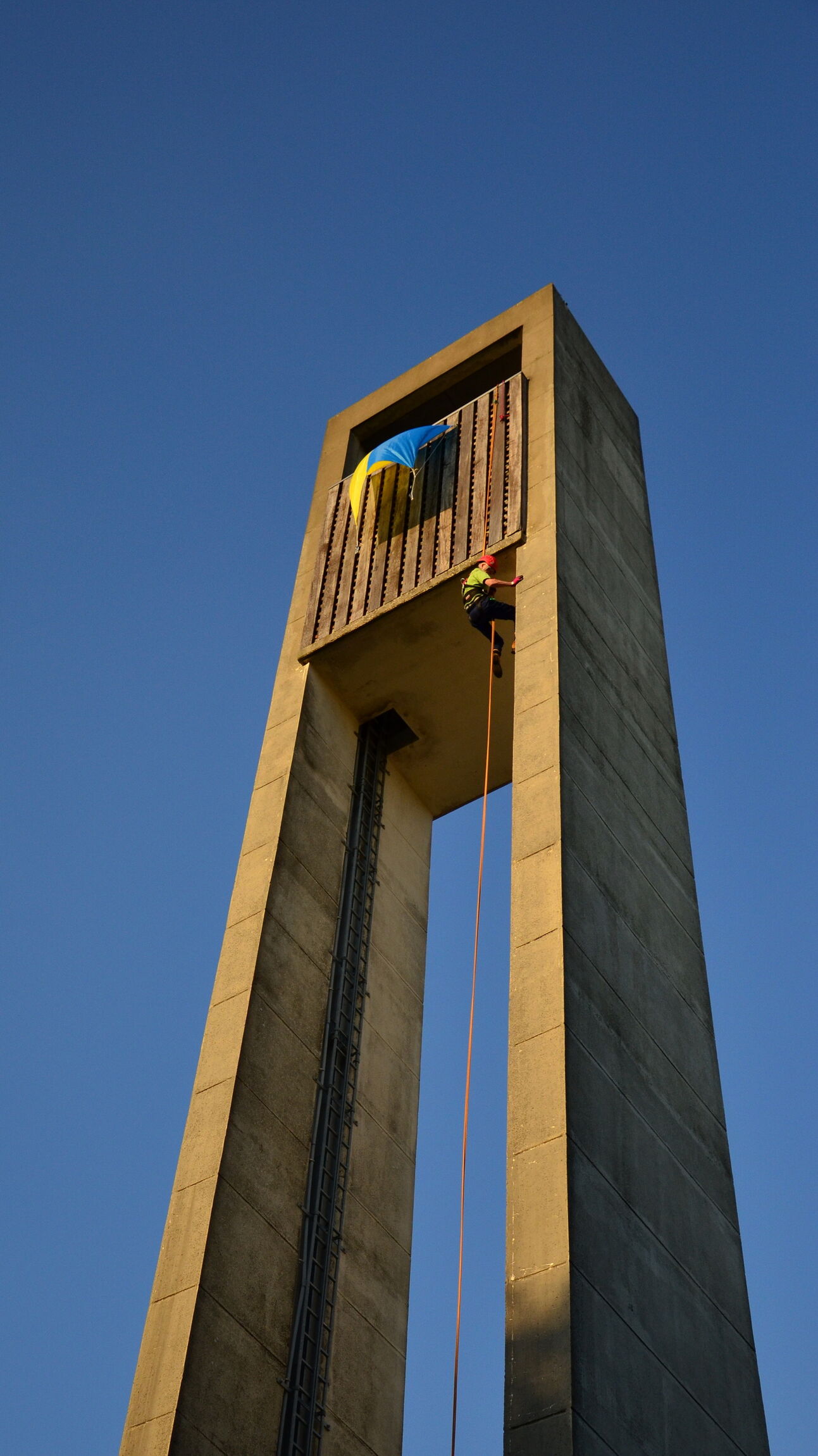 Kletterer bringt ukrainische Flagge an