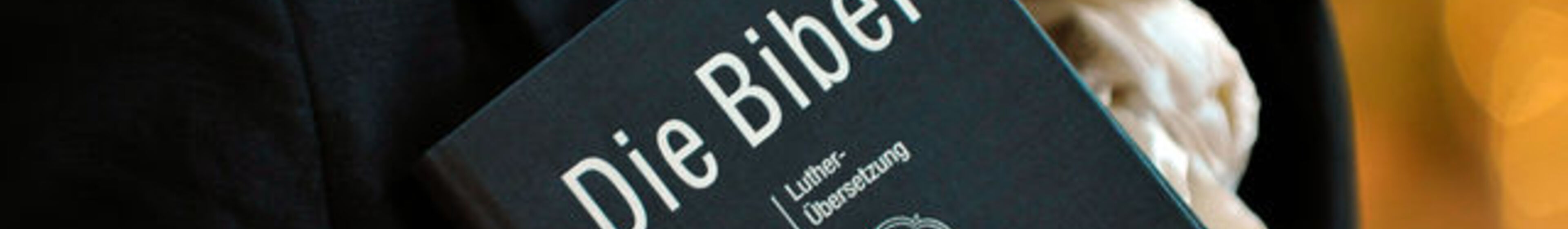 Frau hält eine Lutherbibel in der Marktkirche in Hannover.