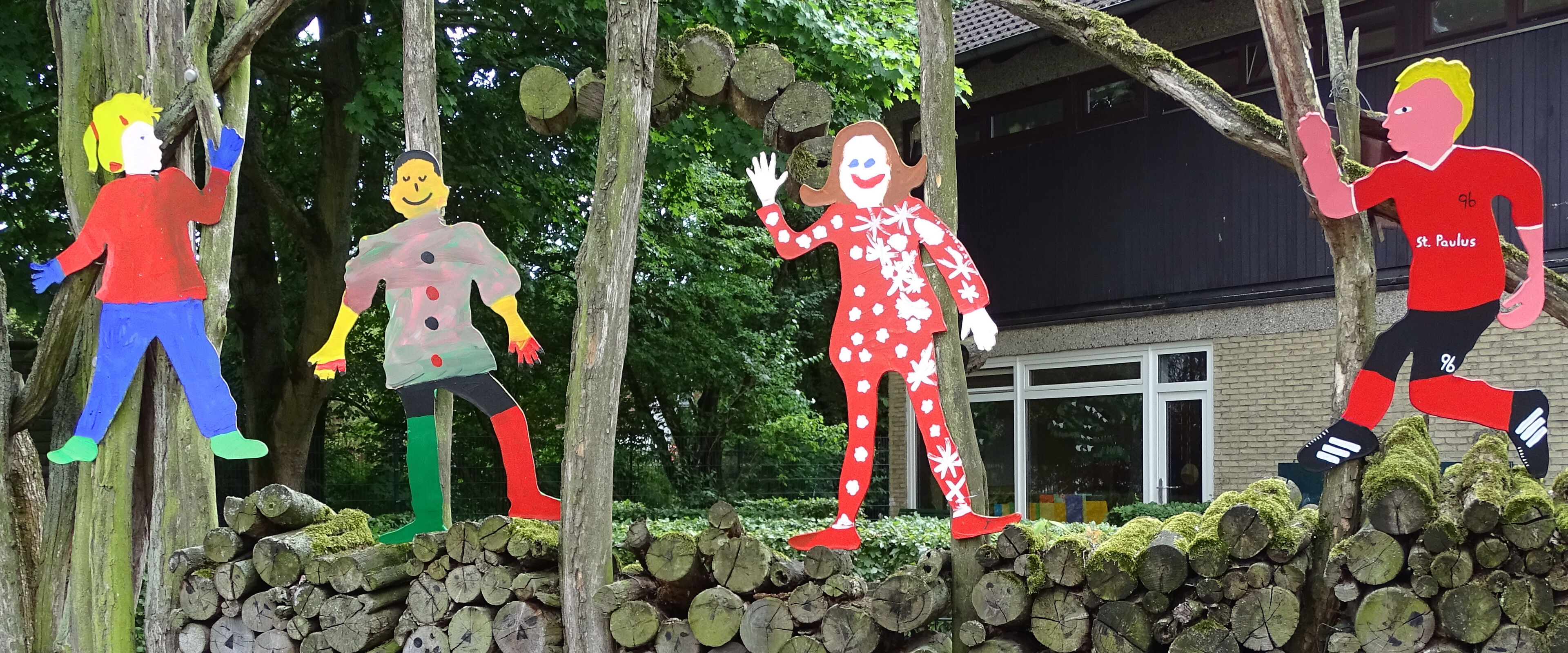 Kinder aus Holz vor dem Kiga